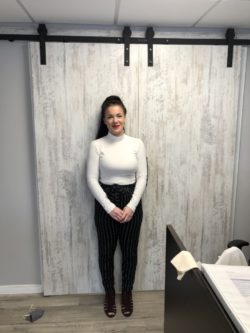 A woman standing in front of a white door