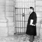 A man standing in front of a caged door