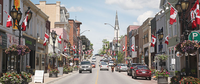 A street with canadian flags hanging off the lamp posts